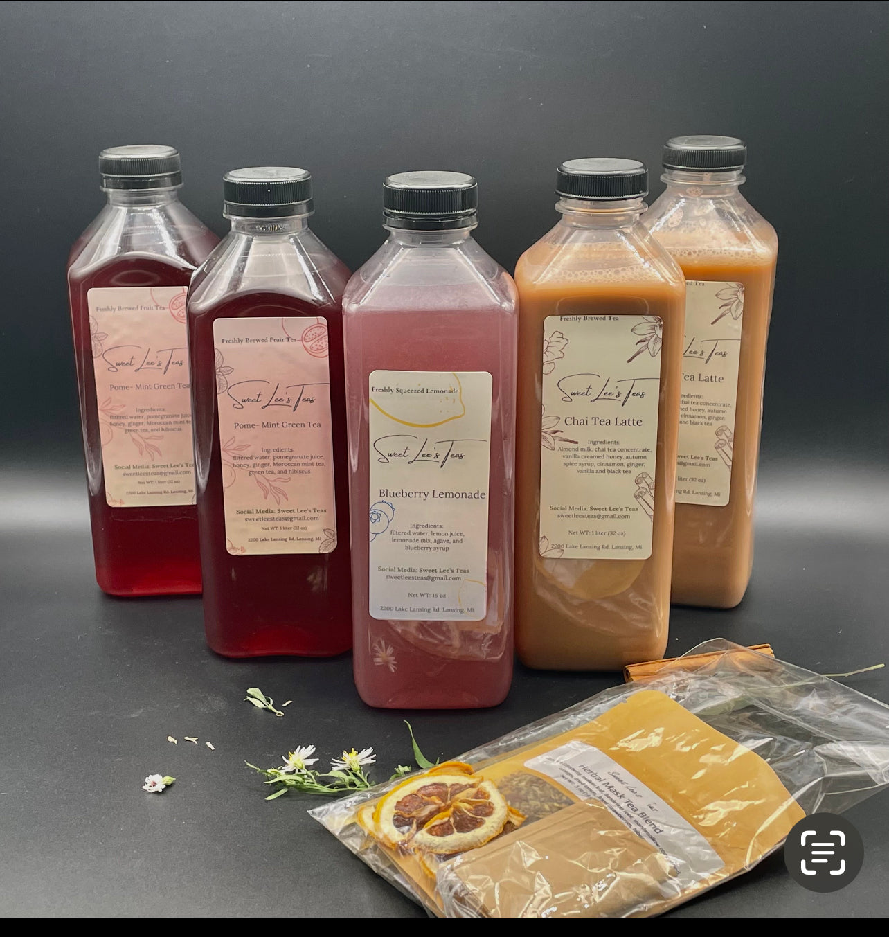 A selection of bottled teas from Sweet Lee’s Teas, including Pome-Mint Green Tea, Blueberry Lemonade, and Chai Tea Latte, alongside a tea kit with loose-leaf tea, dried citrus, and reusable tea bags, showcasing the variety in the monthly tea box.