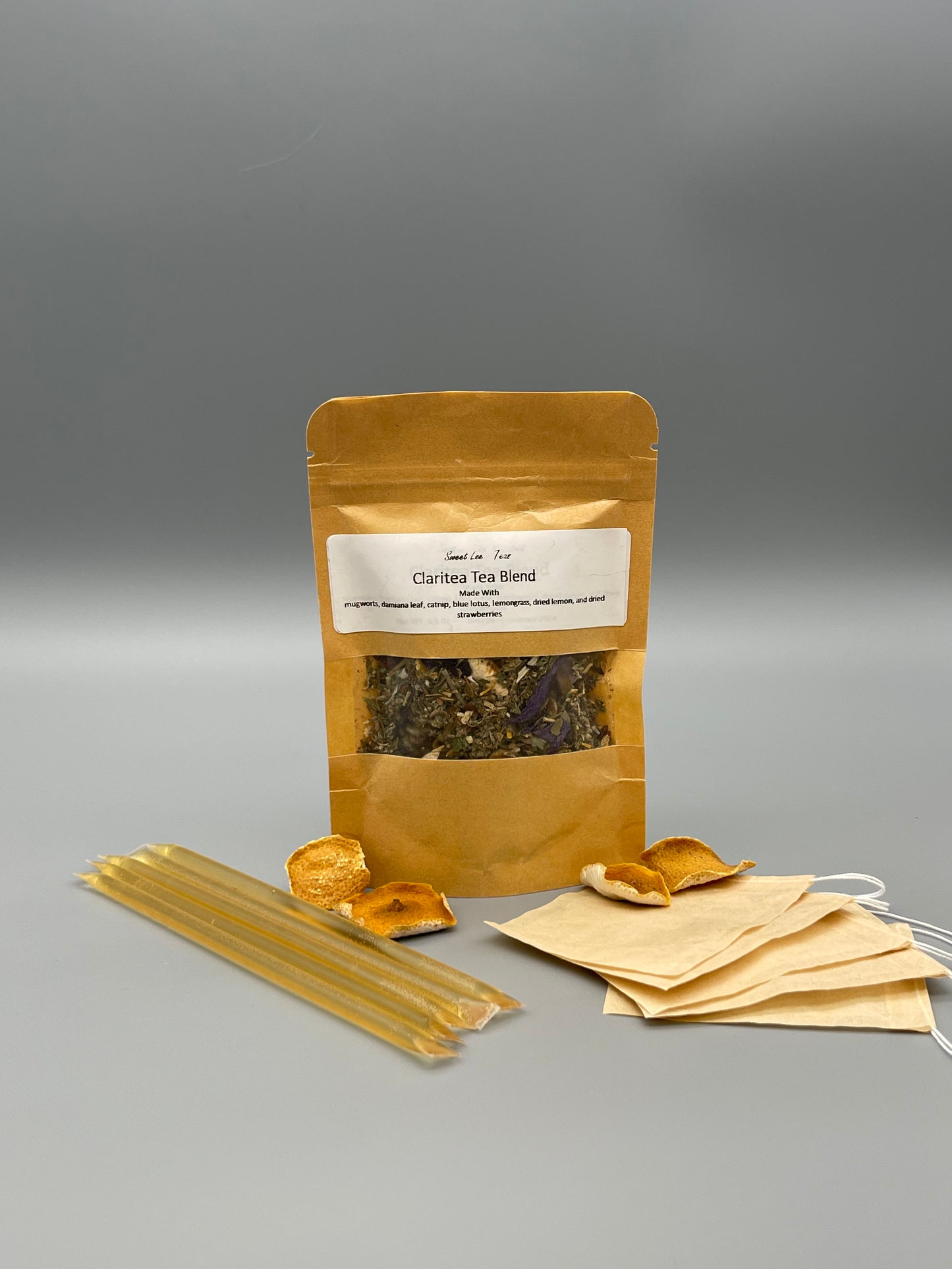 Sweet Lee’s Teas Iced Tea Kit featuring a kraft bag of Claritea Tea Blend, natural honey sticks, reusable tea bags, and dried citrus slices, providing everything needed for brewing refreshing iced tea.